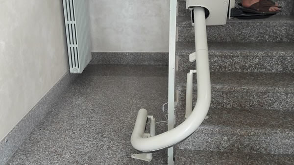 Foto di scale e rotaia di un montascale curvilineo monoguida installato presso un edificio del paese di La Morra
