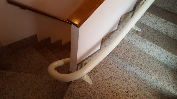 Particolare di un Montascale con poltroncina, modello curvilineo monoguida della ditta Montascale 2c ed installato all'interno di un palazzo situato a Borgo San Dalmazzo