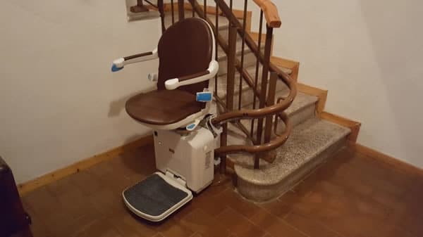 Visuale delle scale di una casa di Ponzone con montascale curvilineo a doppia guida realizzato dalla ditta Montascale 2C