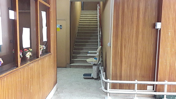 Montascale in funzione, guida sottile e poltroncina in posizione aperta