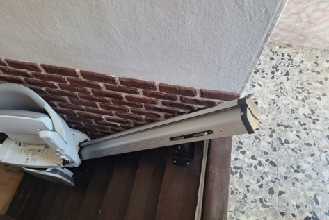 Montascale su scala stretta, particolare rotaia e sedile chiuso